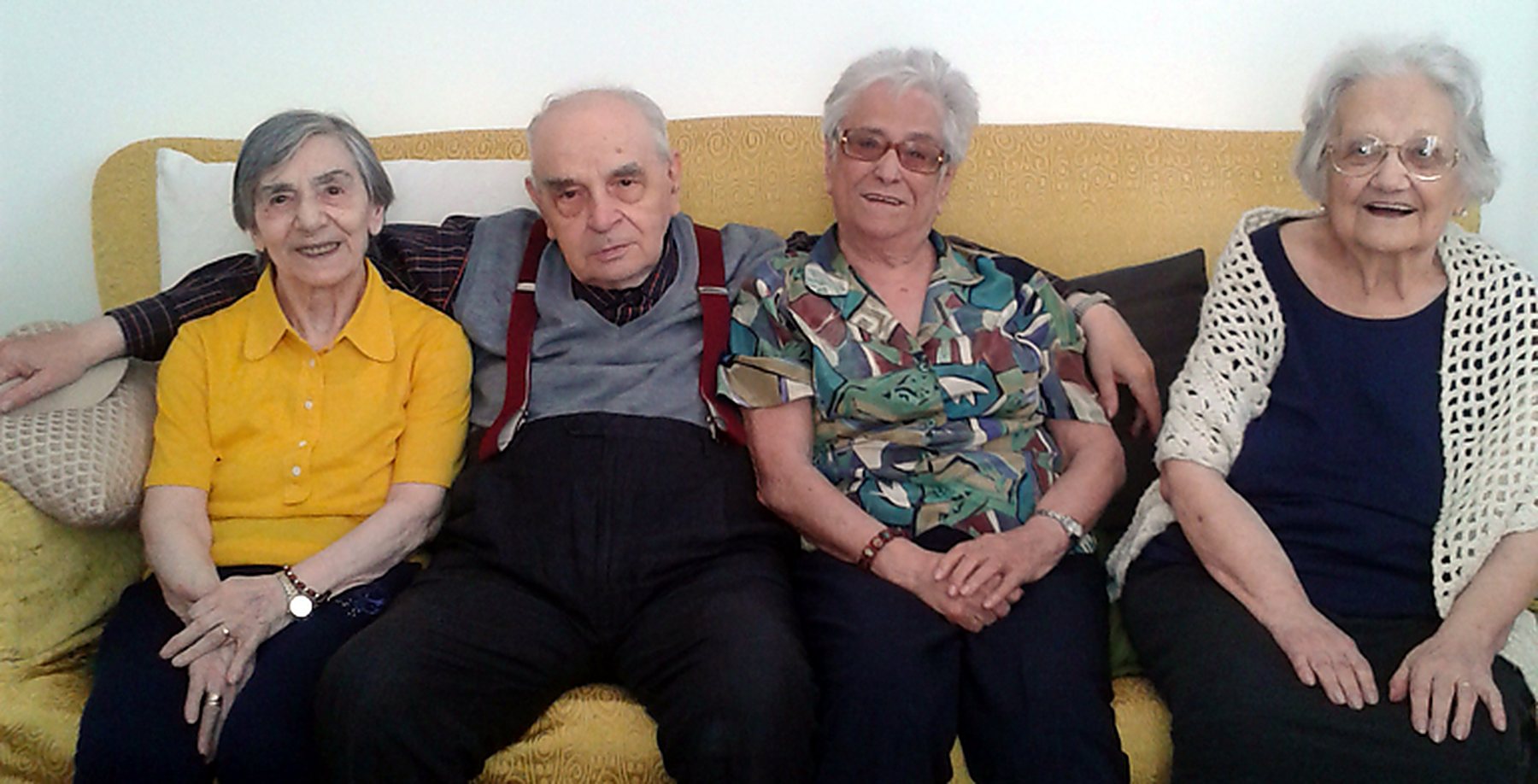 Alcuni ospiti della residenza Agave seduti insieme sul divano del soggiorno